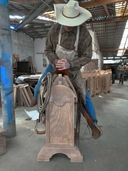Jorge Kurczyn demonstrating the strength and stability of a handcrafted saddle stand